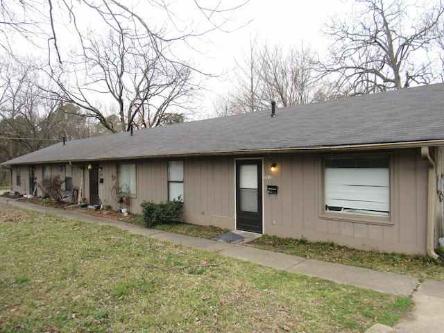 ranch-style home featuring a front yard and a shingled roof