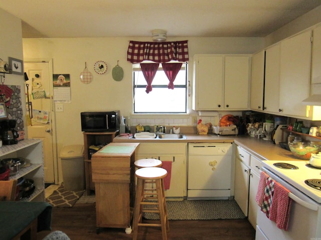 kitchen with a sink, dark wood-style floors, white cabinetry, white appliances, and light countertops