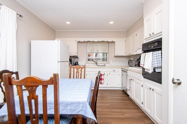 kitchen featuring crown molding, freestanding refrigerator, a sink, black oven, and dishwasher