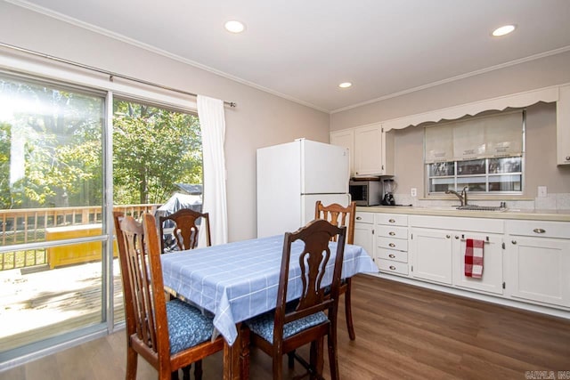 dining space with recessed lighting, dark wood-style flooring, and crown molding