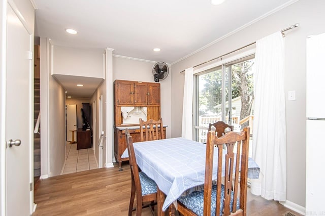 dining room featuring light wood finished floors, baseboards, ornamental molding, and recessed lighting