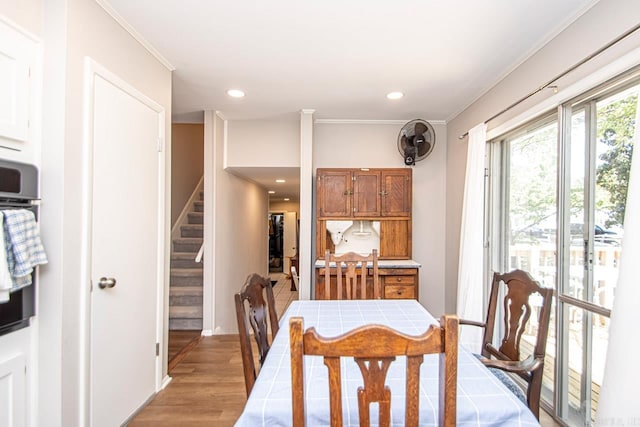 dining space with light wood-type flooring, recessed lighting, stairway, and ornamental molding