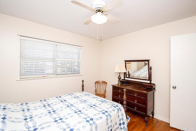 bedroom featuring a ceiling fan, baseboards, and wood finished floors