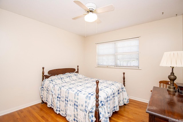 bedroom with a ceiling fan, baseboards, and wood finished floors