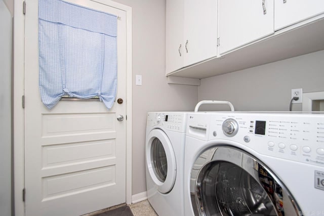 clothes washing area featuring cabinet space, baseboards, and washing machine and clothes dryer