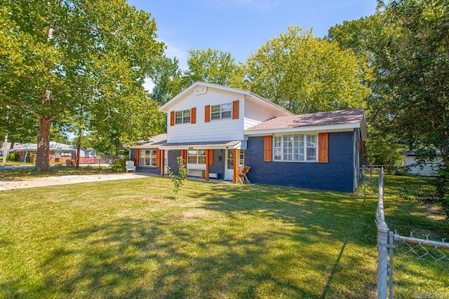 split level home featuring a front yard, brick siding, and fence