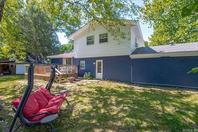 back of house with a wooden deck, a lawn, and brick siding