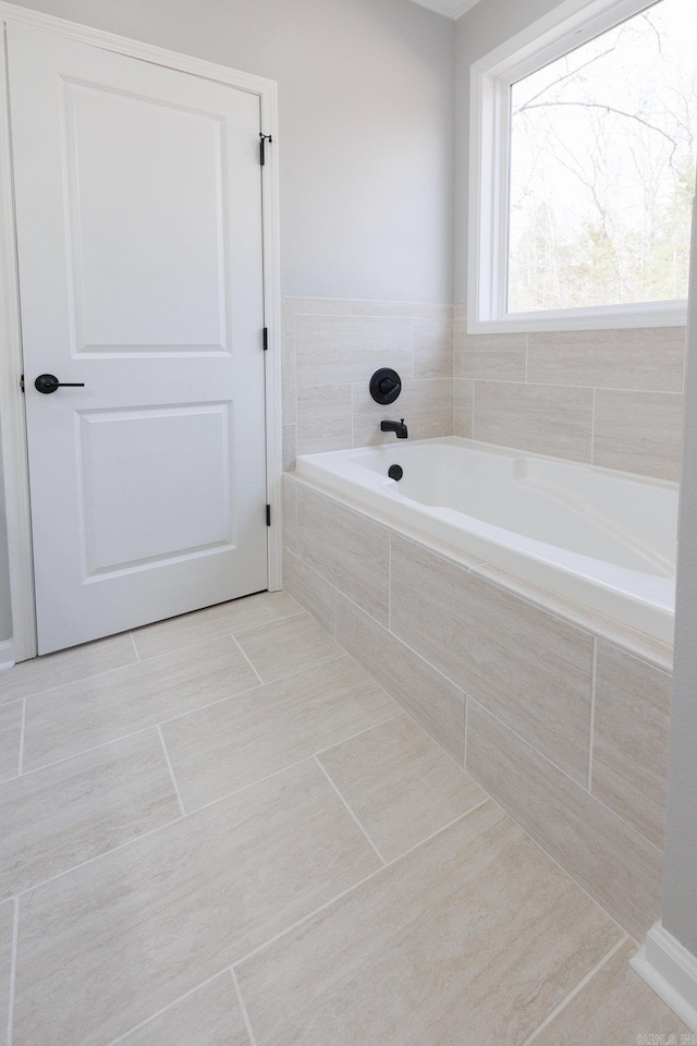 bathroom with tile patterned flooring and a garden tub