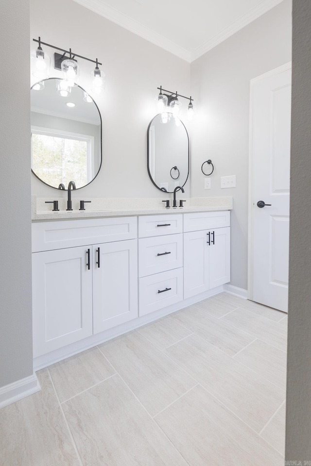 bathroom featuring baseboards, crown molding, a sink, and double vanity