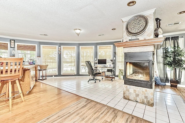 interior space featuring wood finished floors, a multi sided fireplace, visible vents, and crown molding