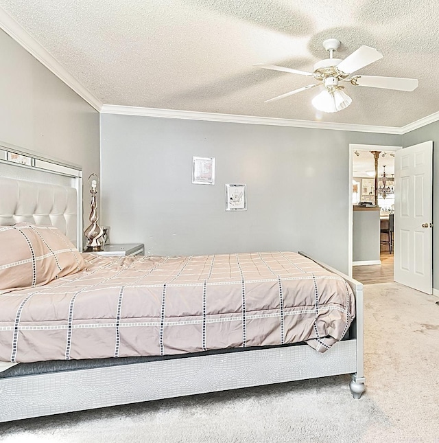 carpeted bedroom with ornamental molding, ceiling fan, and a textured ceiling