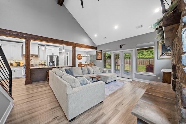 living room featuring light wood finished floors, visible vents, high vaulted ceiling, and french doors