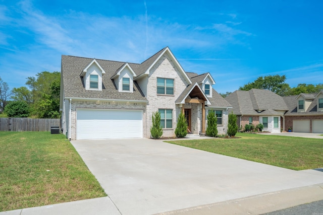 view of front of property with brick siding, a shingled roof, concrete driveway, a front yard, and fence