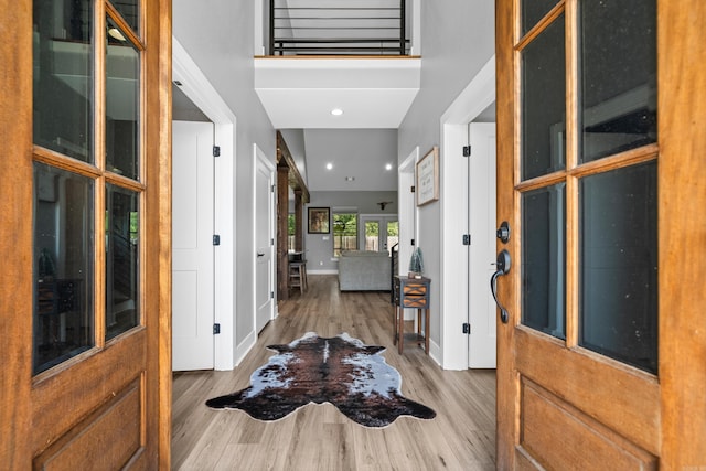 entrance foyer featuring a high ceiling, baseboards, wood finished floors, and recessed lighting