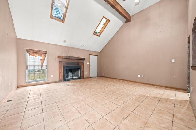 unfurnished living room featuring a skylight, beam ceiling, a fireplace, light tile patterned flooring, and high vaulted ceiling