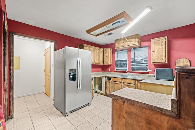 kitchen with a sink, light tile patterned flooring, stainless steel fridge, and visible vents