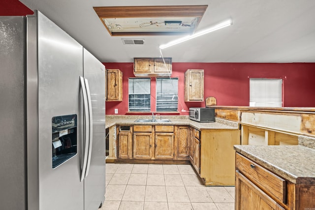 kitchen with light tile patterned floors, visible vents, appliances with stainless steel finishes, a sink, and a peninsula