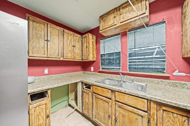 kitchen featuring light tile patterned floors, light countertops, and a sink