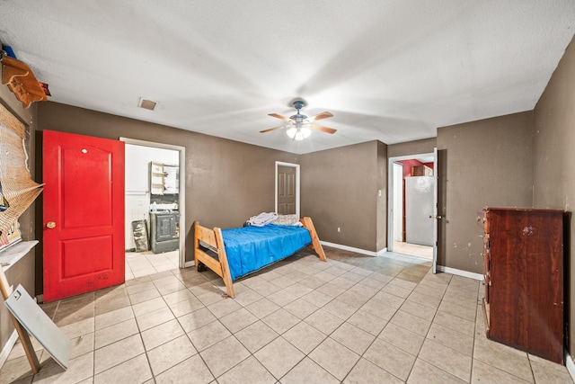 unfurnished bedroom featuring light tile patterned floors, baseboards, visible vents, and a textured ceiling