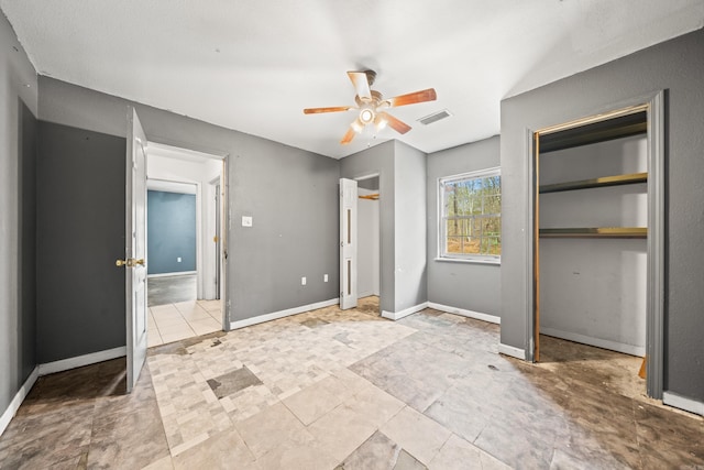 unfurnished bedroom featuring baseboards, visible vents, ceiling fan, and multiple closets