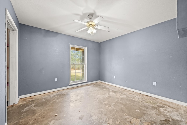 unfurnished room featuring baseboards, ceiling fan, and unfinished concrete floors