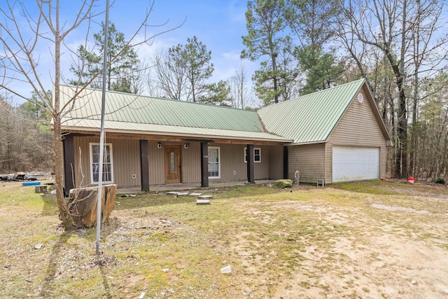 view of front of property with an attached garage, covered porch, and metal roof