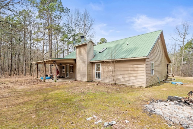 rear view of house with a yard, a chimney, a patio, metal roof, and ceiling fan