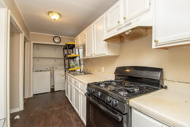 kitchen featuring black gas range, under cabinet range hood, washing machine and dryer, and white cabinetry