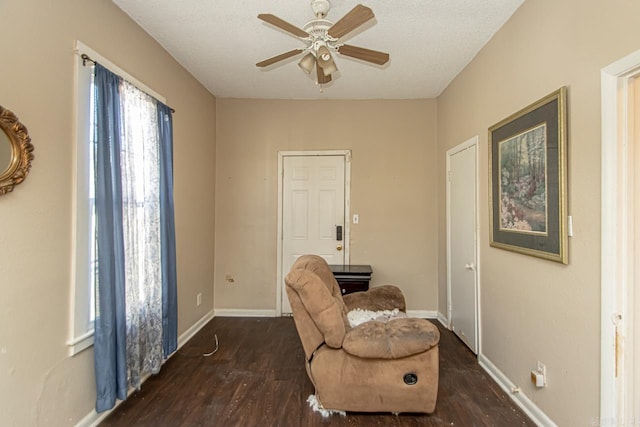 sitting room featuring ceiling fan, a textured ceiling, baseboards, and wood finished floors