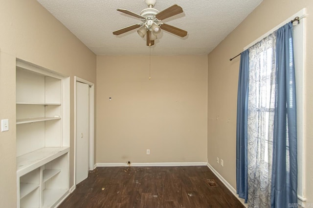 spare room featuring a ceiling fan, a textured ceiling, baseboards, and wood finished floors