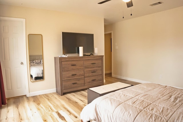 bedroom featuring light wood-style flooring, visible vents, ceiling fan, and baseboards