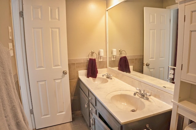 full bathroom featuring tile patterned flooring, a sink, tile walls, and double vanity