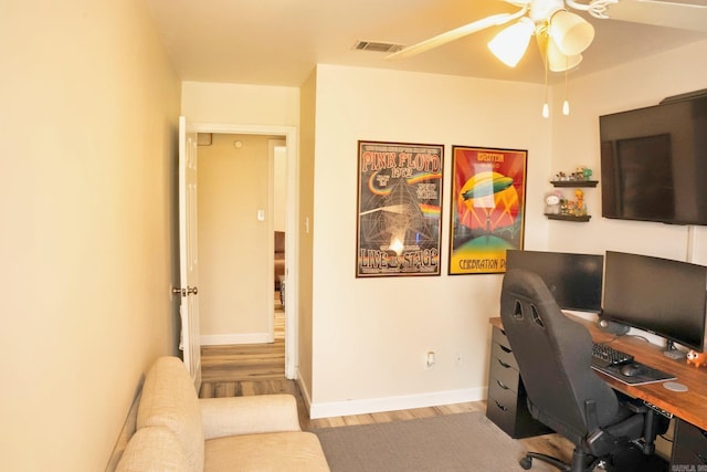 home office featuring a ceiling fan, visible vents, baseboards, and wood finished floors