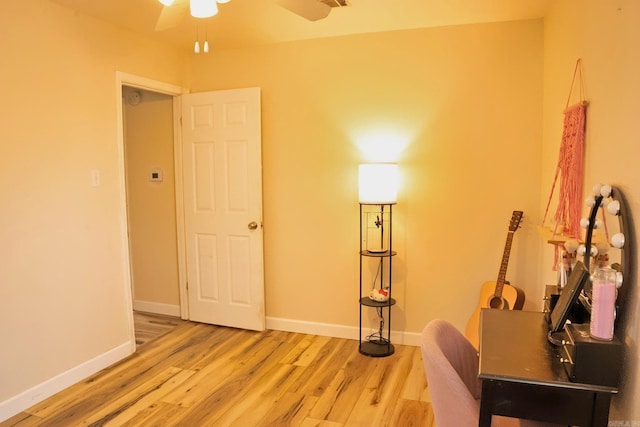 unfurnished room with a ceiling fan, baseboards, and wood finished floors