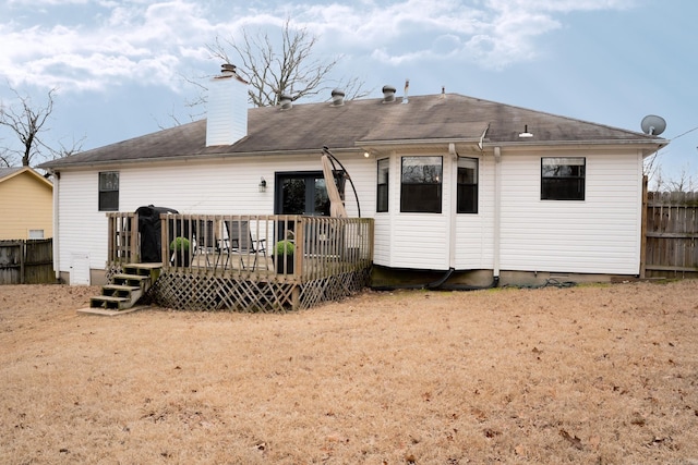 back of house featuring a chimney, fence, and a wooden deck