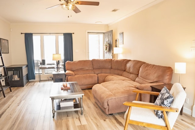 living area featuring ceiling fan, ornamental molding, visible vents, and light wood-style flooring