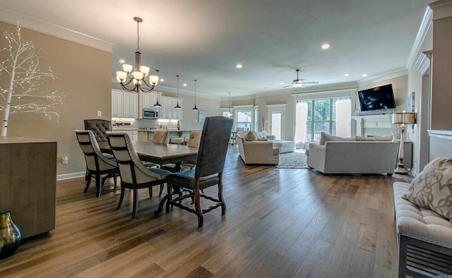 dining area featuring ornamental molding, a fireplace, baseboards, and wood finished floors
