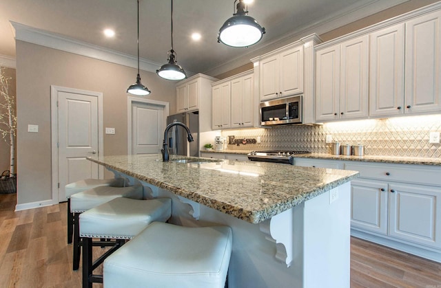 kitchen with stainless steel appliances, light wood finished floors, a breakfast bar area, and decorative backsplash