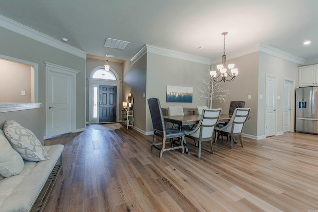 dining area with light wood finished floors, visible vents, baseboards, and a notable chandelier