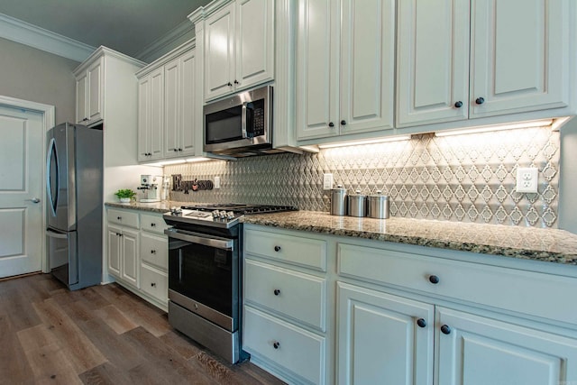 kitchen with dark wood-style floors, crown molding, decorative backsplash, appliances with stainless steel finishes, and white cabinetry