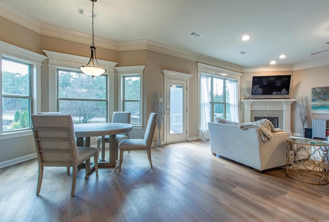 dining area featuring plenty of natural light, a fireplace, visible vents, and wood finished floors