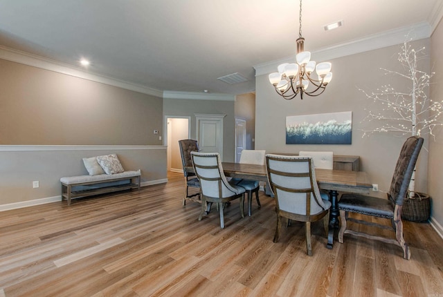 dining space with light wood-type flooring, an inviting chandelier, visible vents, and crown molding