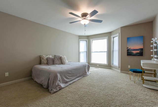 carpeted bedroom featuring ceiling fan and baseboards