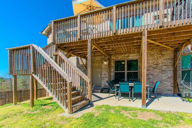 view of patio / terrace featuring fence, a deck, and stairs
