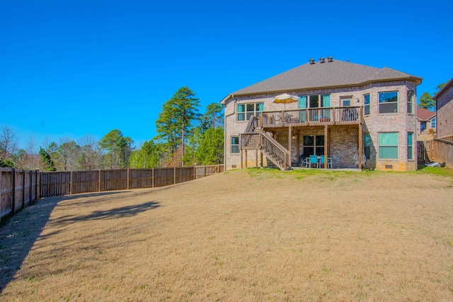 back of property with a lawn, crawl space, a deck, a fenced backyard, and stairs