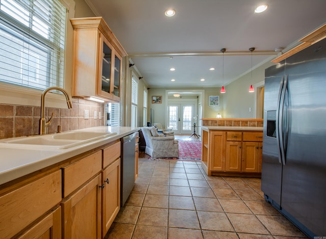 kitchen featuring light tile patterned floors, light countertops, stainless steel appliances, french doors, and a sink