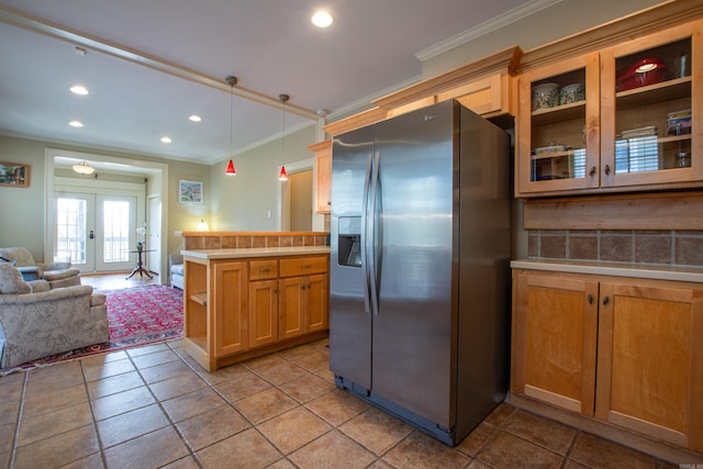 kitchen with crown molding, light countertops, french doors, and stainless steel fridge with ice dispenser