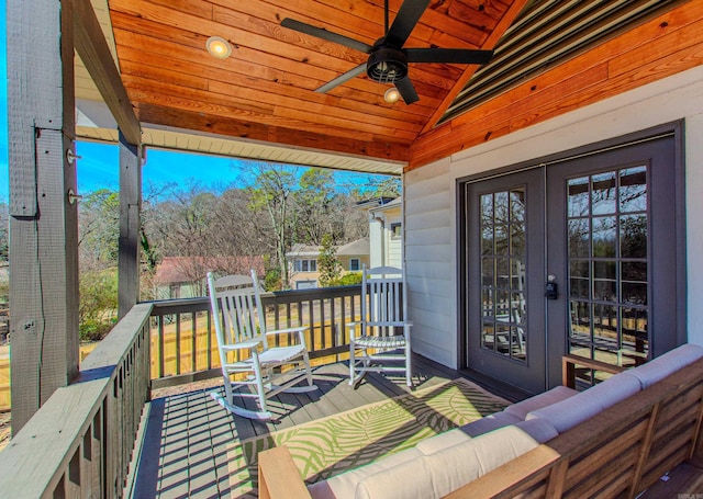 wooden deck with ceiling fan and french doors