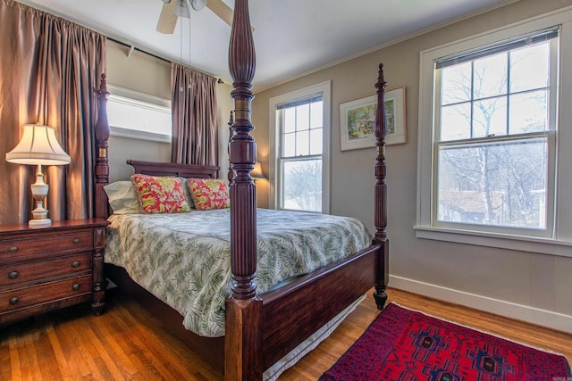 bedroom featuring ornamental molding, a ceiling fan, baseboards, and wood finished floors