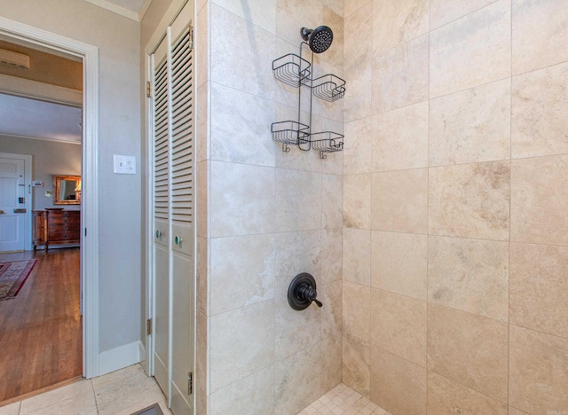 full bathroom featuring ornamental molding and tiled shower